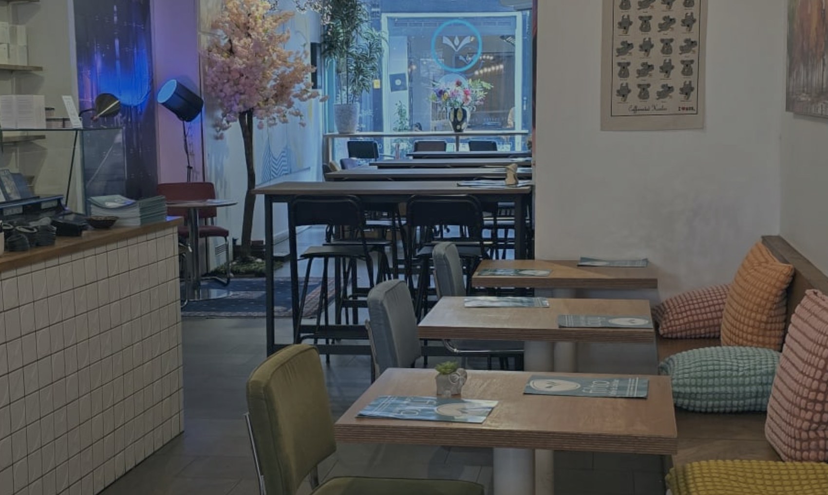 The Filtro dining room with a tiled counter, a cherry blossom tree by the front window, and a cushioned banquette corner